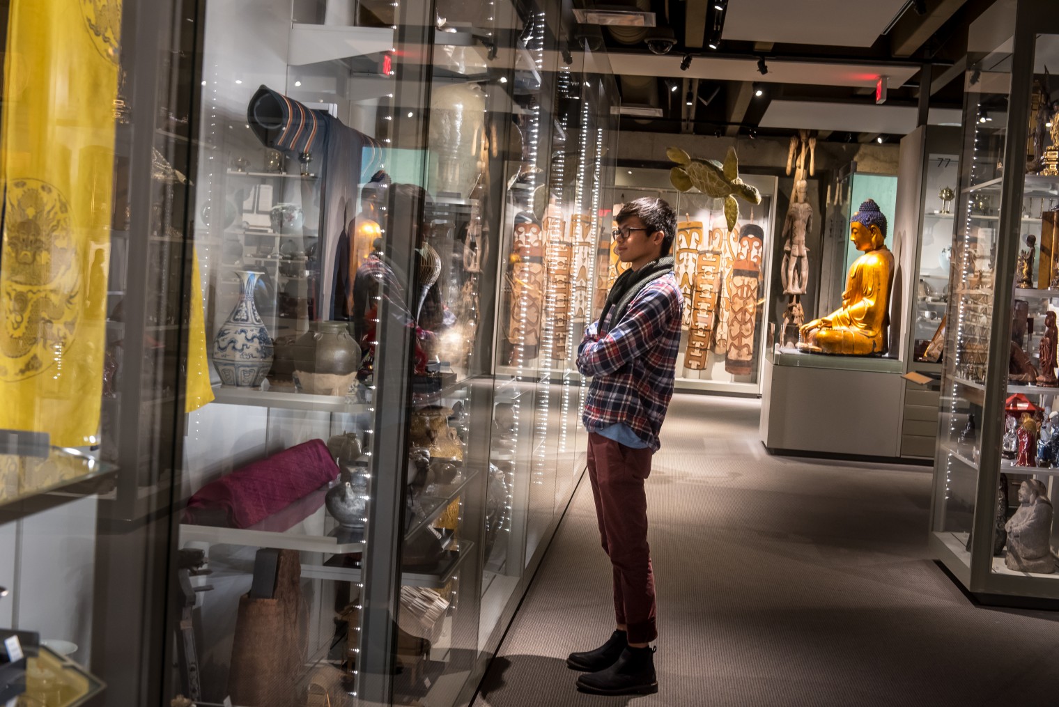 Man looks at artifacts on display at UBC Museum of Anthropology
