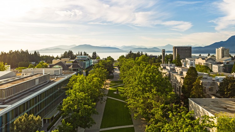 Aerial view of Main Mall with ocean and mountain backdrop at UBC Vancouver campus