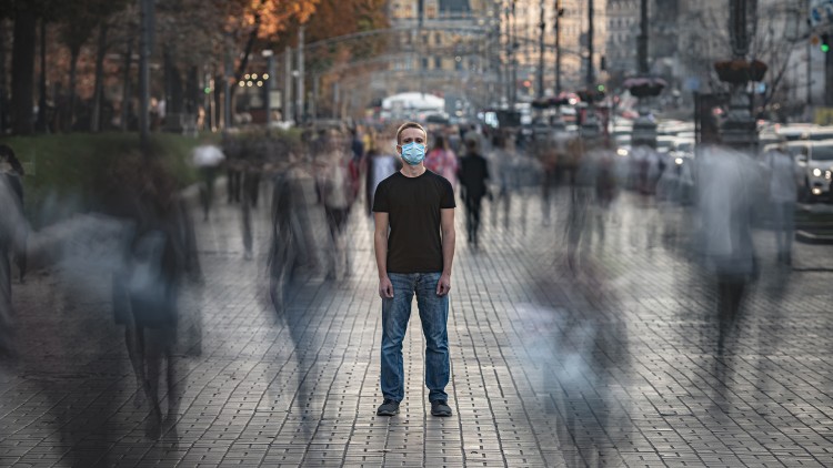 A man wearing a mask on the street.