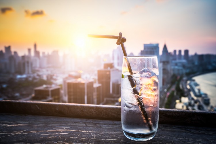 A glass of gin tonic with Shanghai cityscape background.