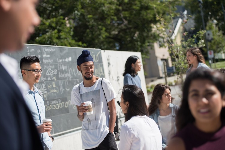 Students meet together for coffee in an outdoor courtyard