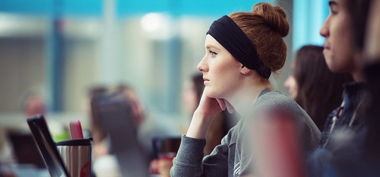 Image of female student sitting in class with other students listening